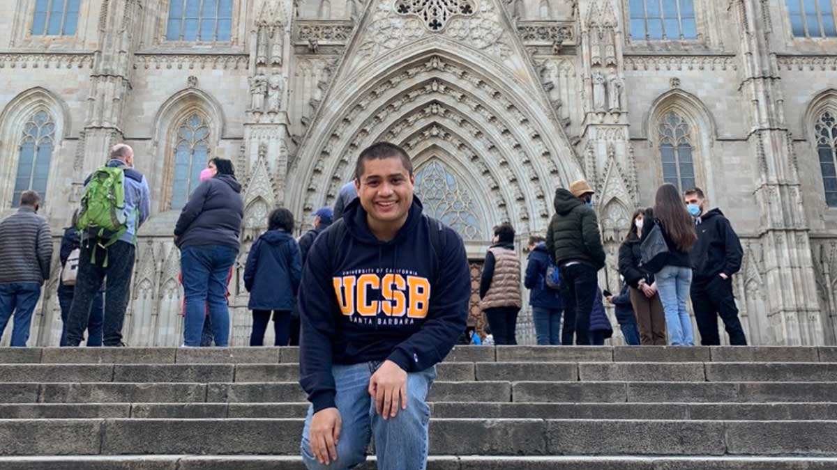 UCSB student smiles for camera on catherdral steps